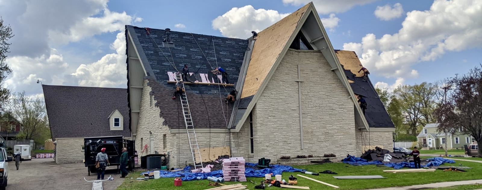 MBE crew replacing the cross on a stone A-frame church steeple