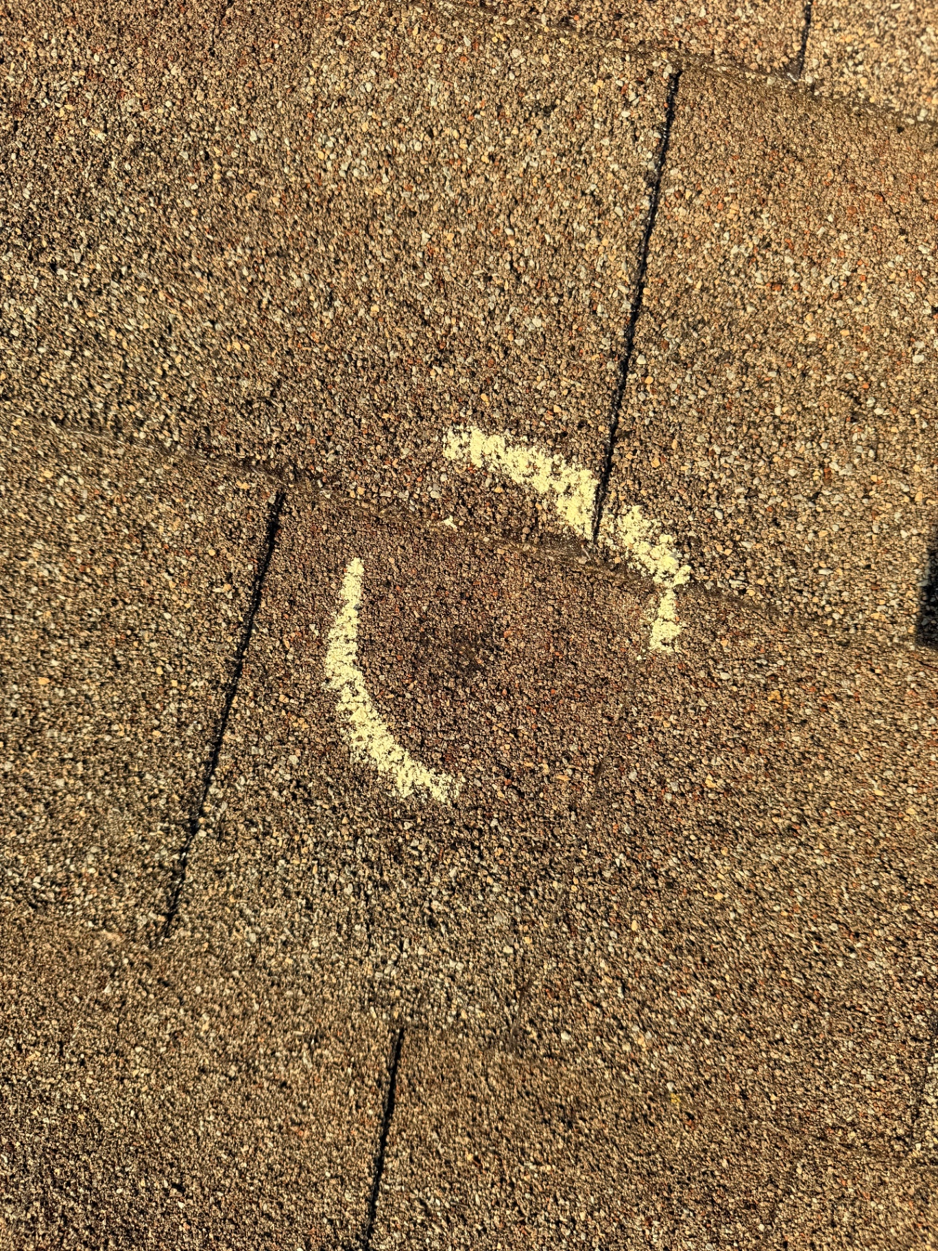 Close-up of a large hail strike with significant granule loss exposing the asphalt mat on a Chisago City, MN roof, marked in chalk