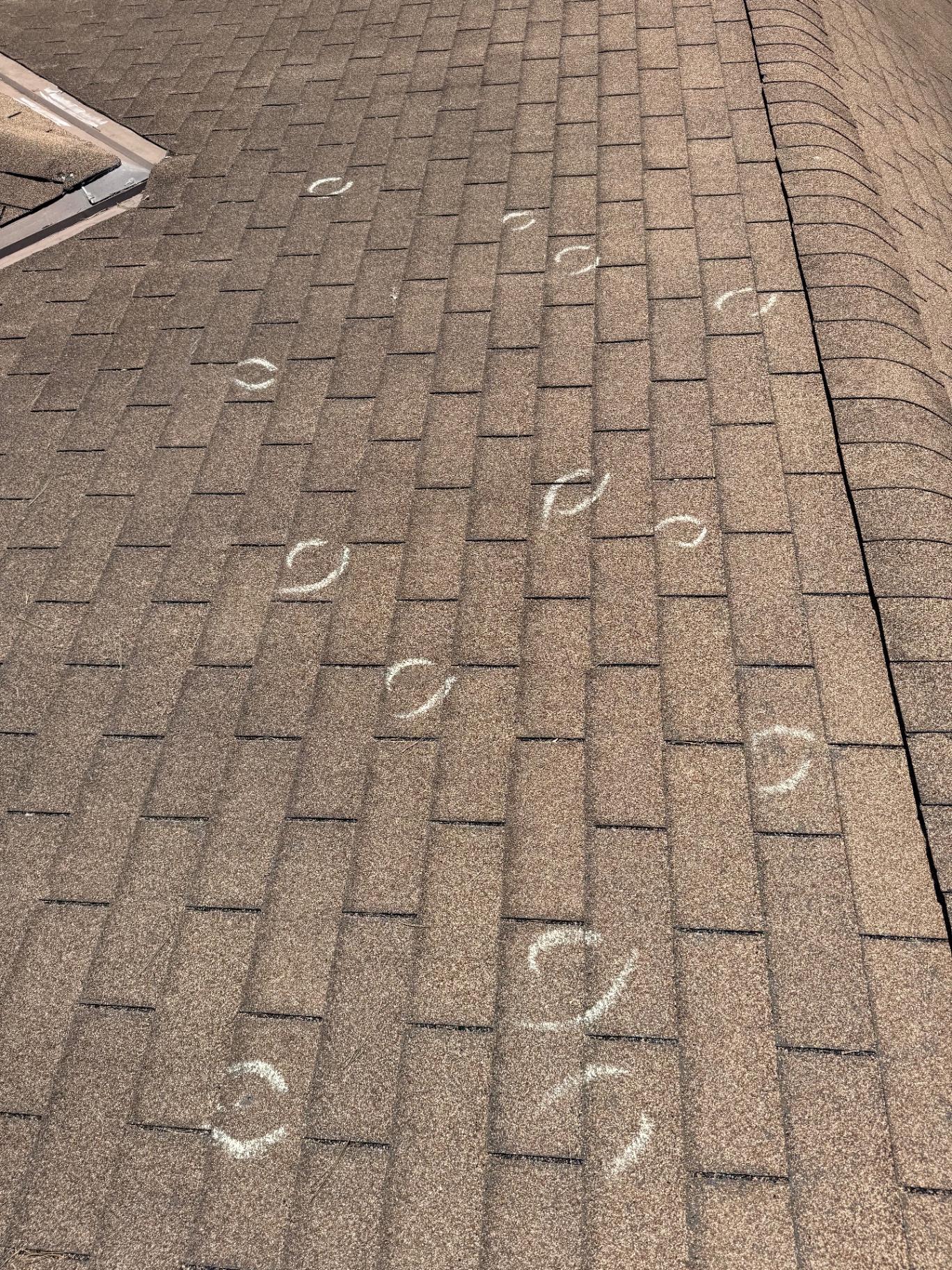 Dozens of chalk-circled hail impact marks documented across a Roseville asphalt shingle roof slope
