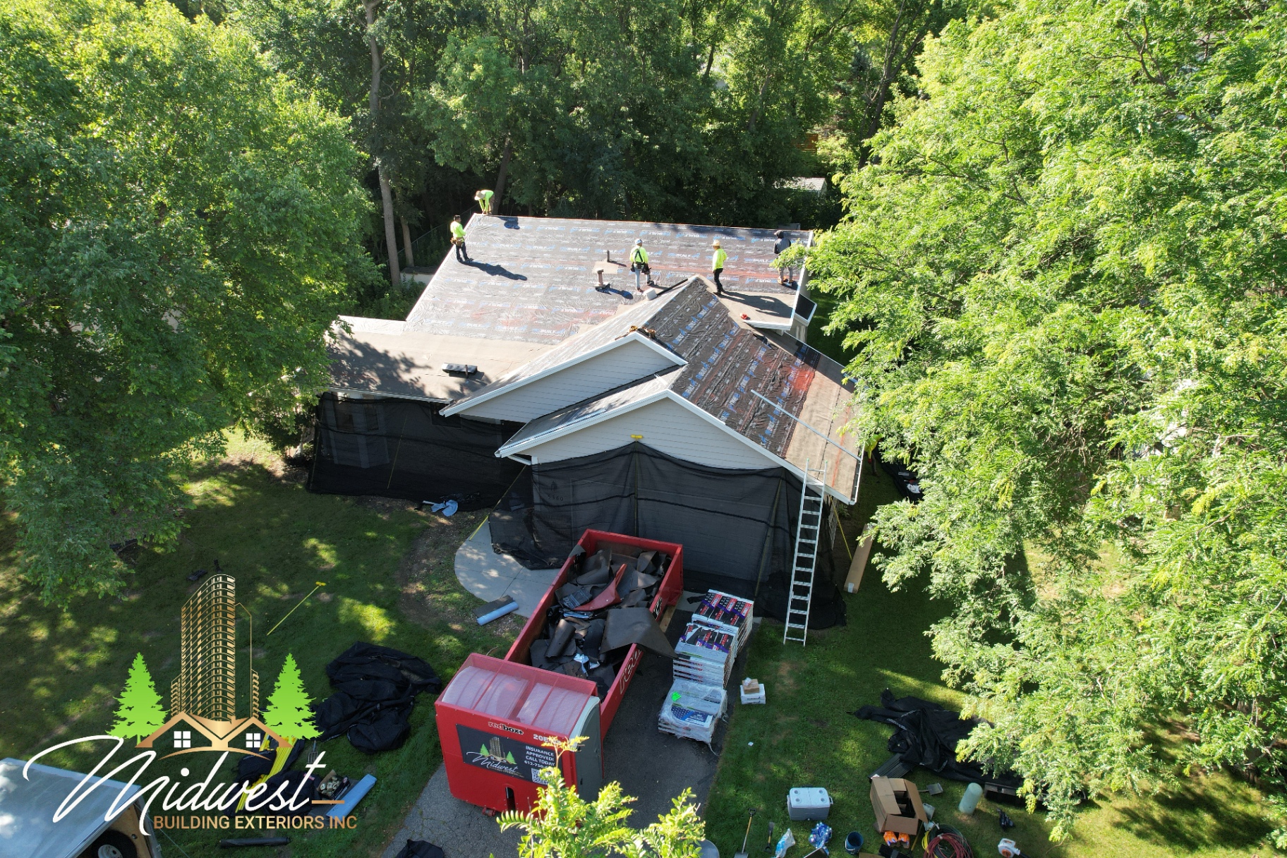 Rear view of storm restoration project with debris containment and tear-off underway