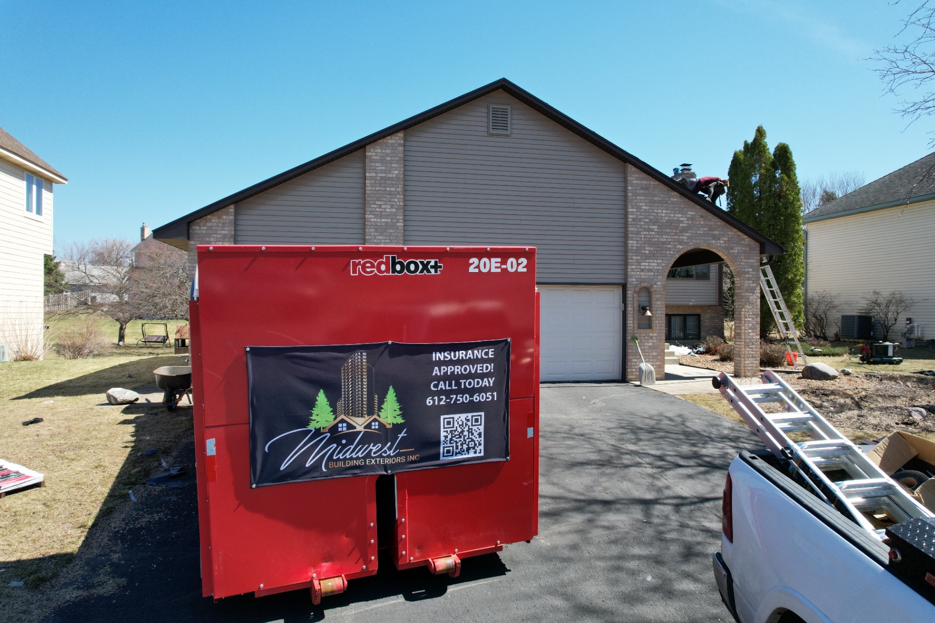 Roofing jobsite with material staging on a residential street near Fridley, MN