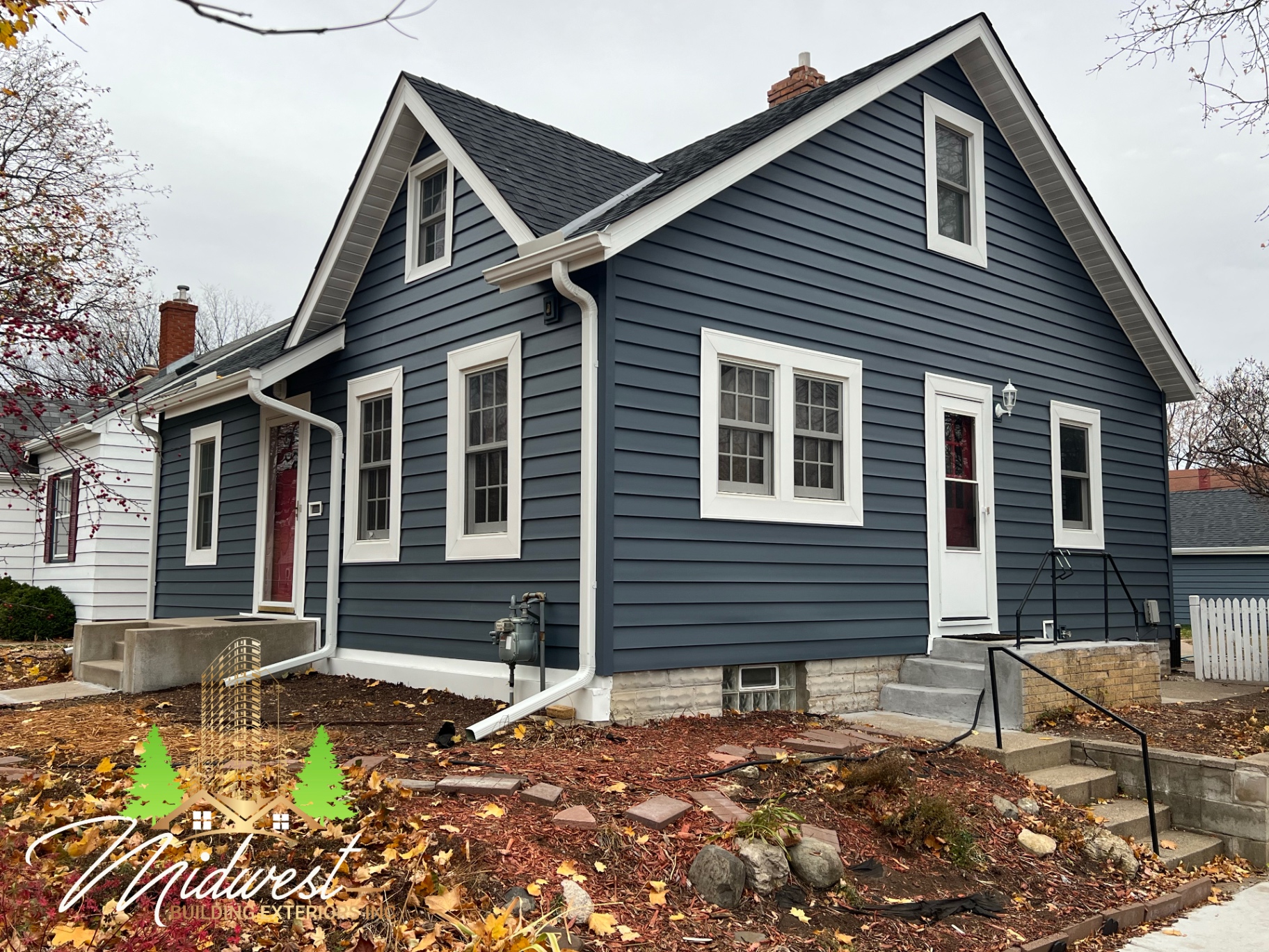 Completed navy-blue lap siding on cape cod home with white trim — South Metro, MN