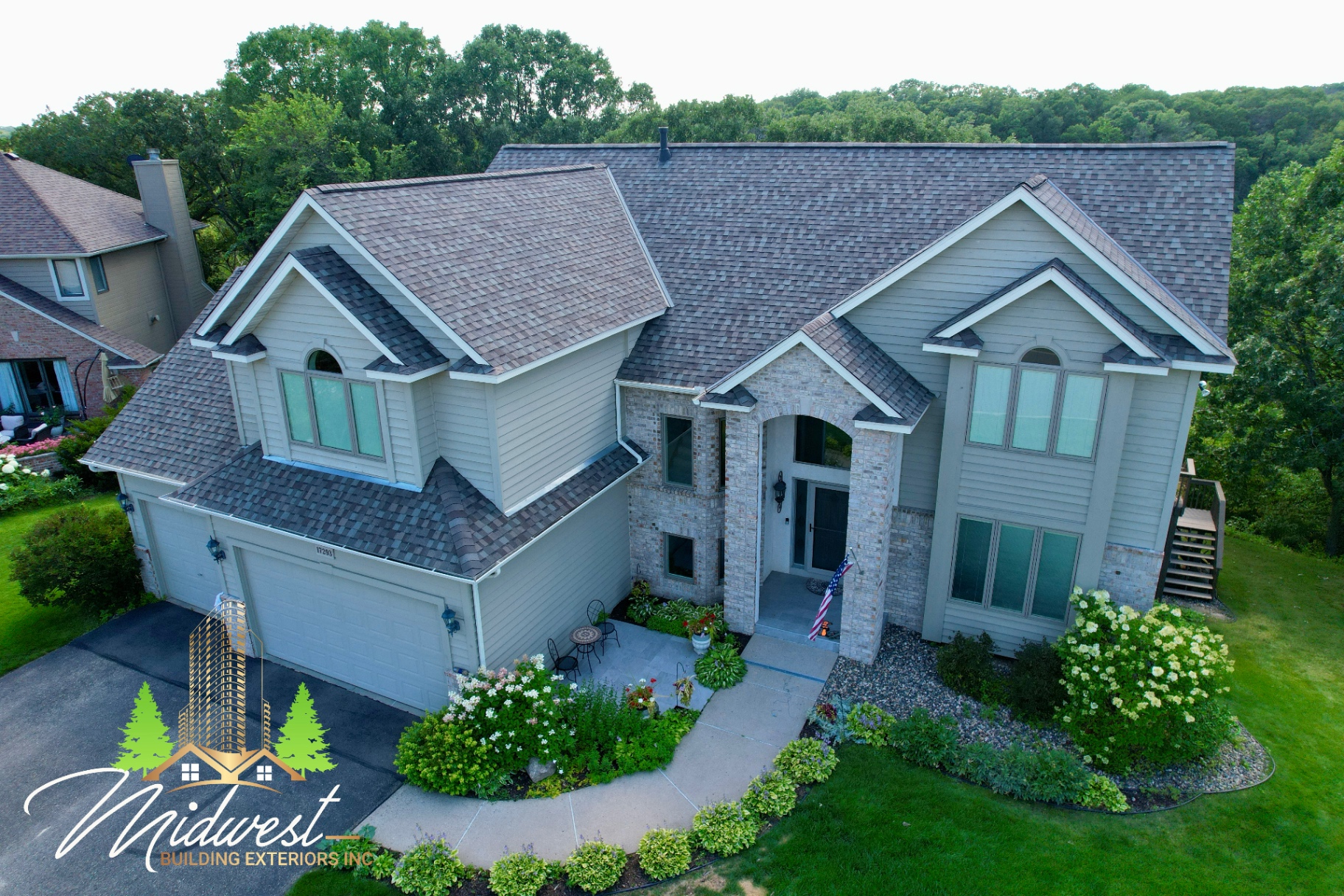 Aerial view of completed siding on two-story home set against wooded backdrop — Eagan, MN